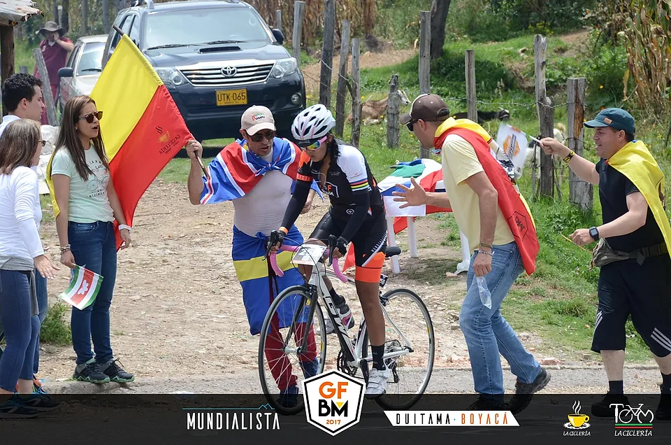Espectadores con banderas animando a los ciclistas en plena subida