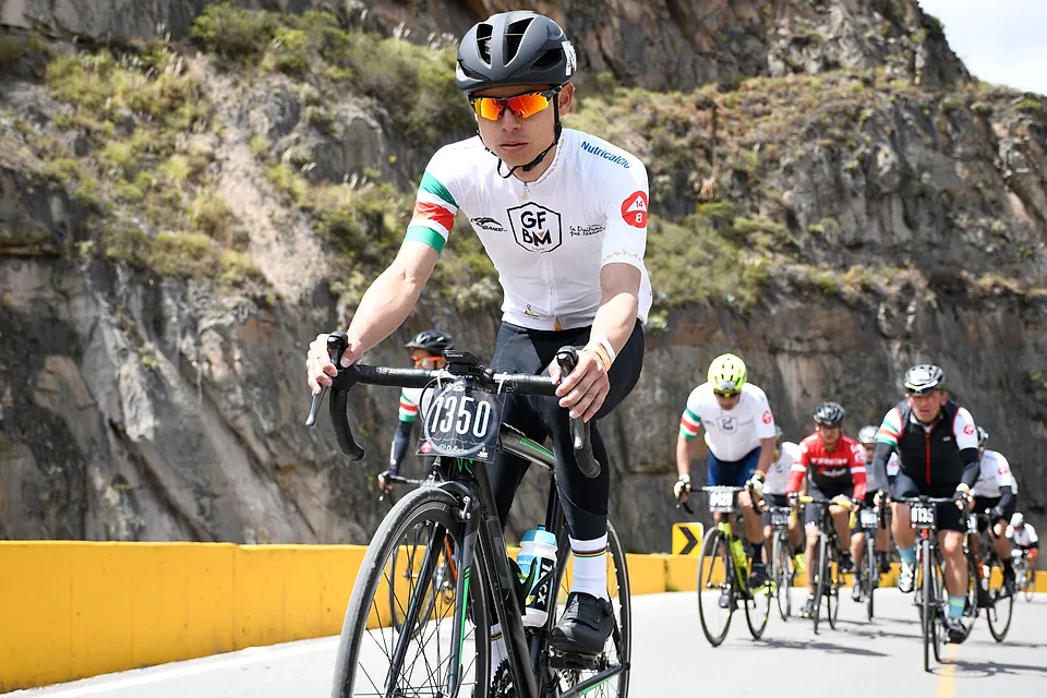 Ciclistas suben la carretera del cañón, bordeada por el muro amarillo