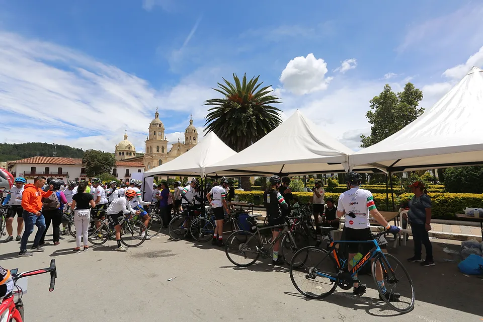 Parada en un pueblo boyacense: carpas, bicicletas y la basílica al fondo