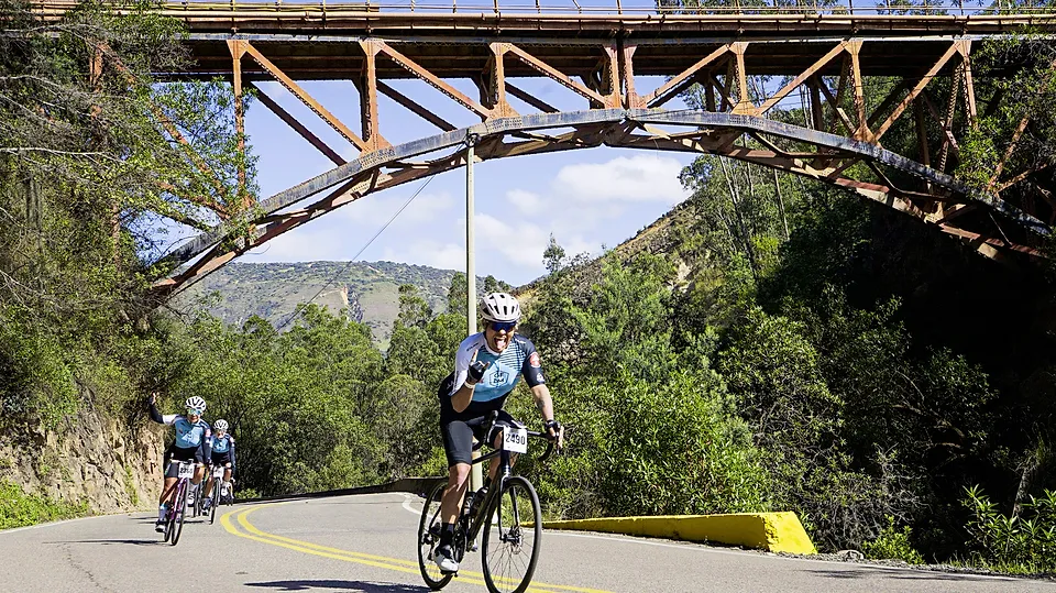 Un ciclista pasa bajo el puente de arco de hierro
