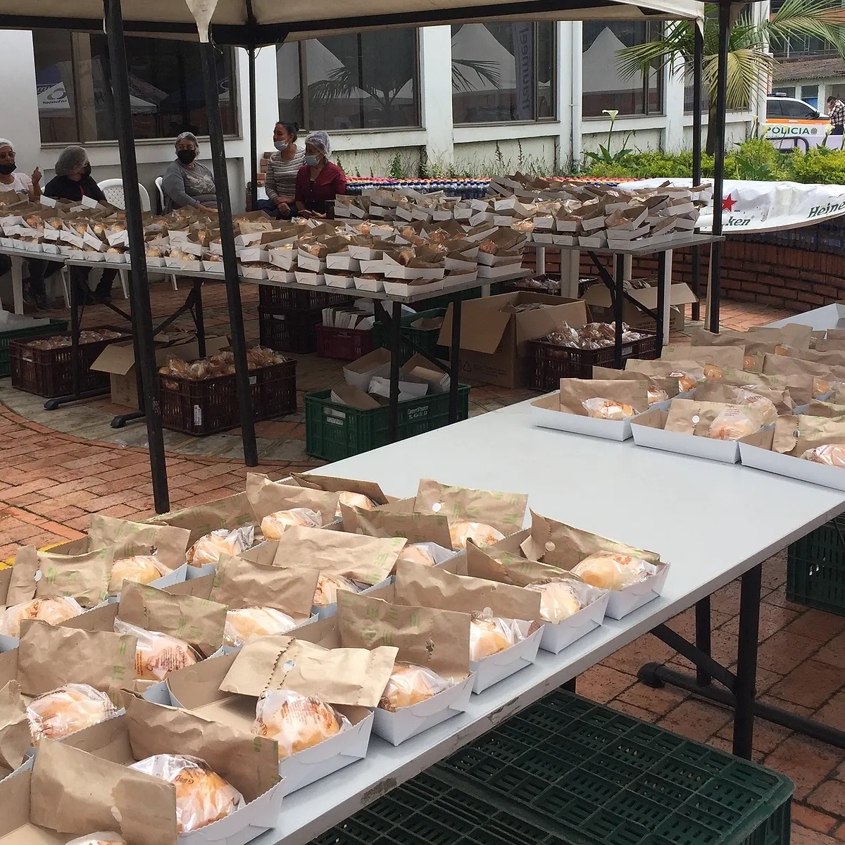 Race-day lunches in paper bags on tables under the Expo tent