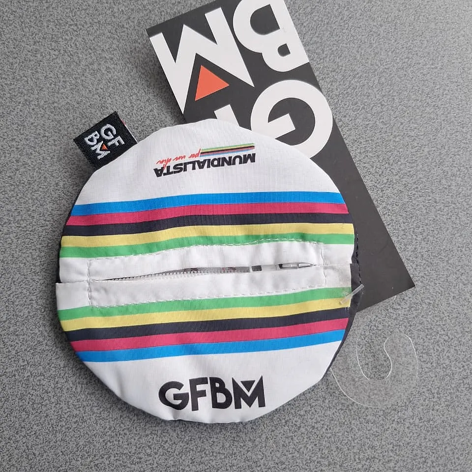 Round GFBM coin purse with the rainbow stripes, the word Mundialista and GFBM in black